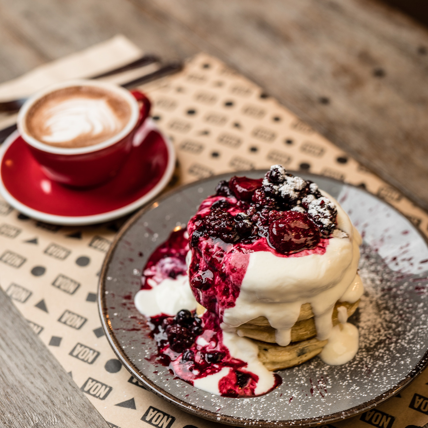 Noa pancake stack with berries and cup of coffee